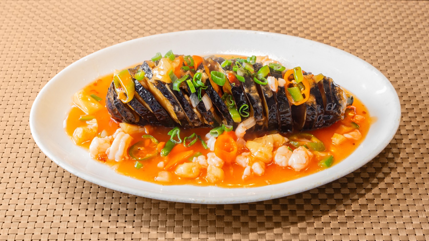 Dragon aubergine crowned with king prawns